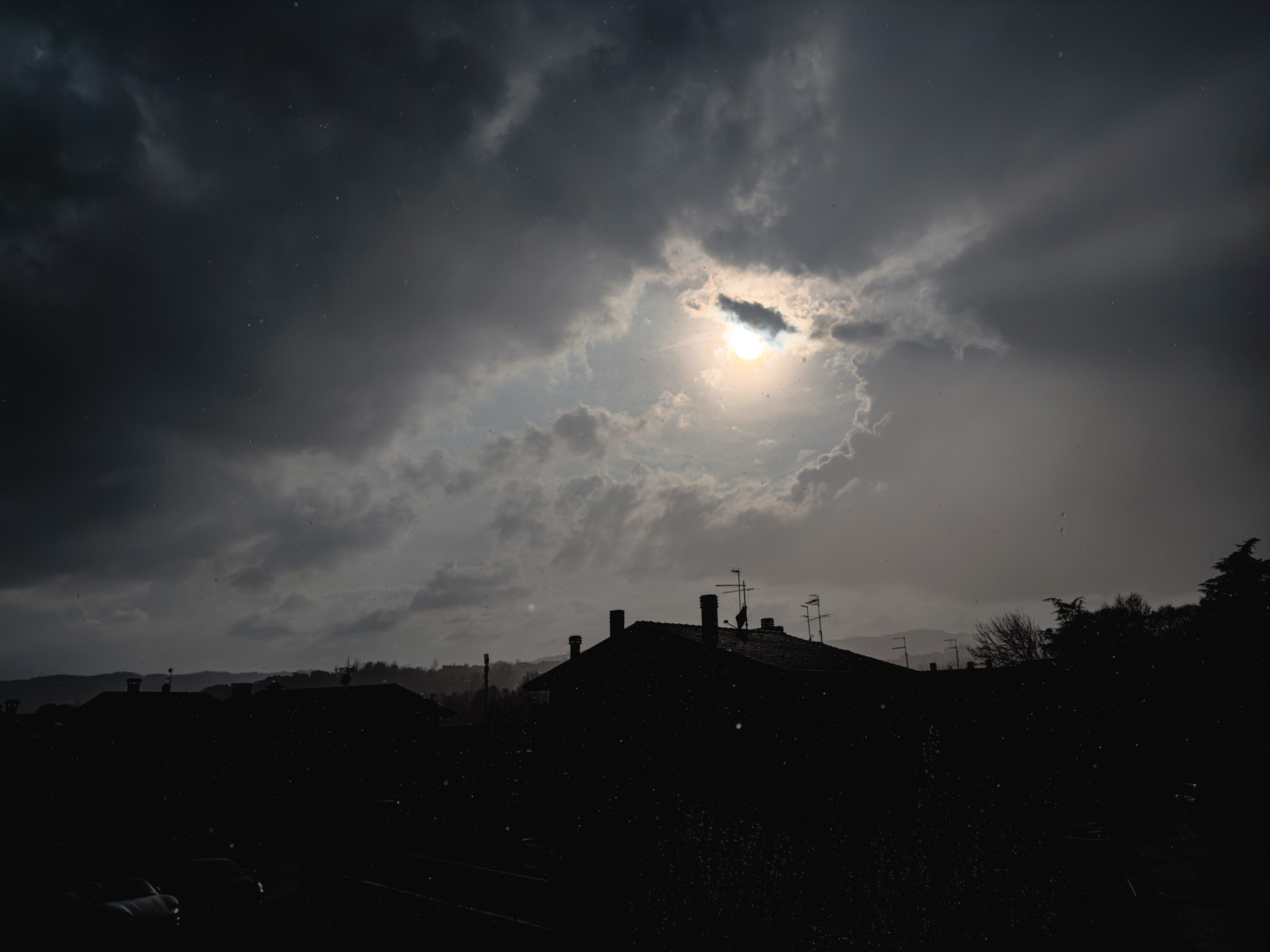 Sunlight breaking through clouds above the rooftops.